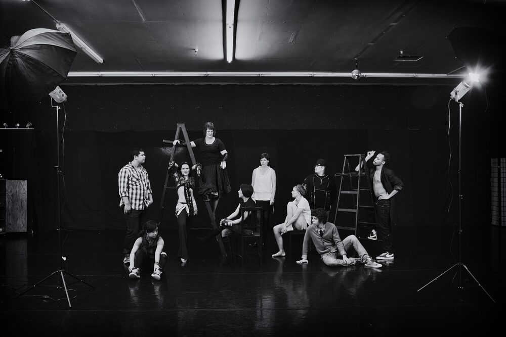 Black and white view of a photo studio with performers and lighting