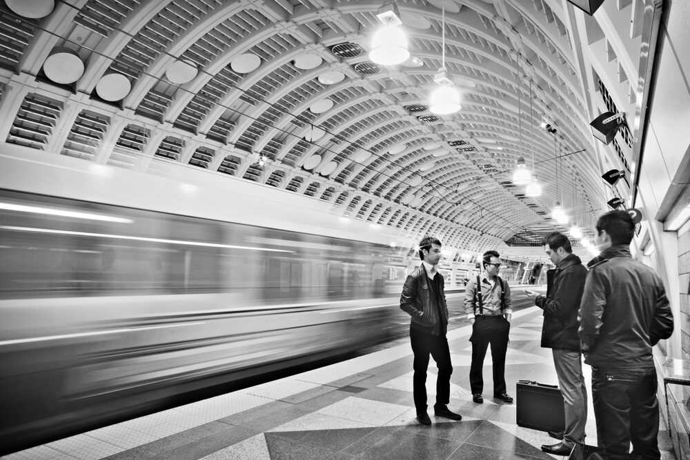 Black and white photo of a band on a subway platform as a train passes