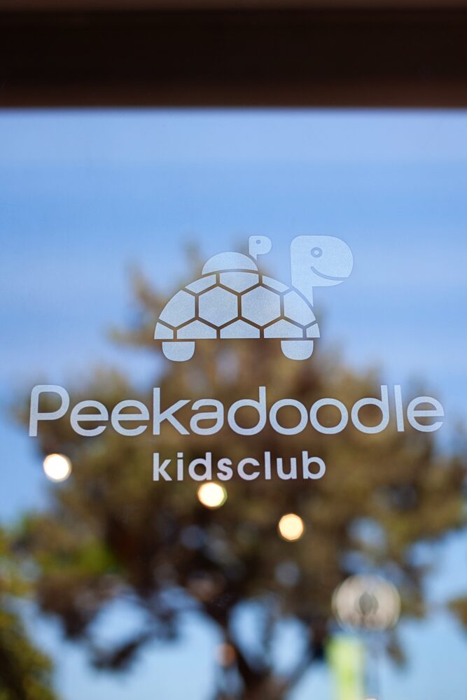Kids club sign with a turtle logo seen through a window