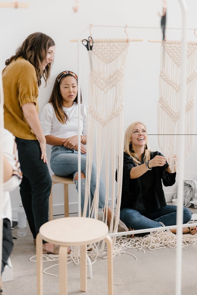 Workshop attendees working on macramé pieces in a bright studio