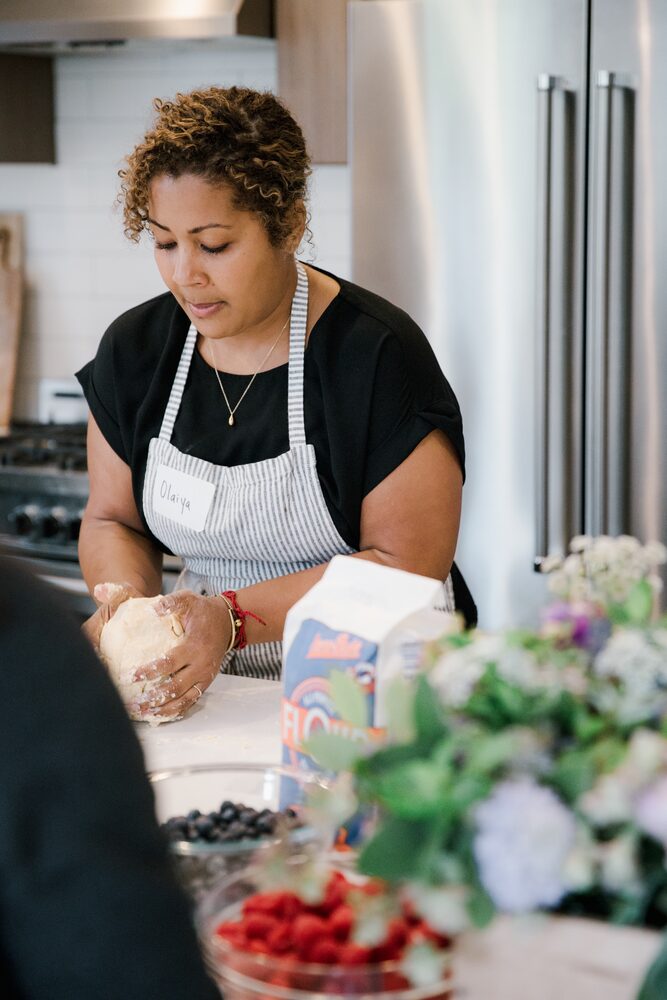 Woman in an apron preparing food at a kitchen counter