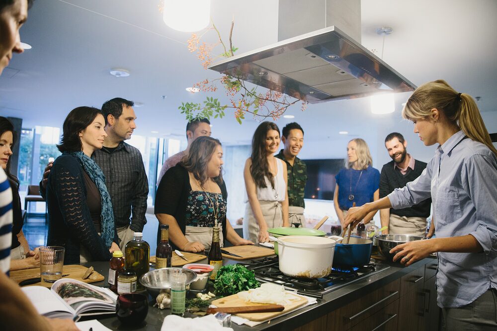 Guests gathered around a kitchen island for a cooking demonstration