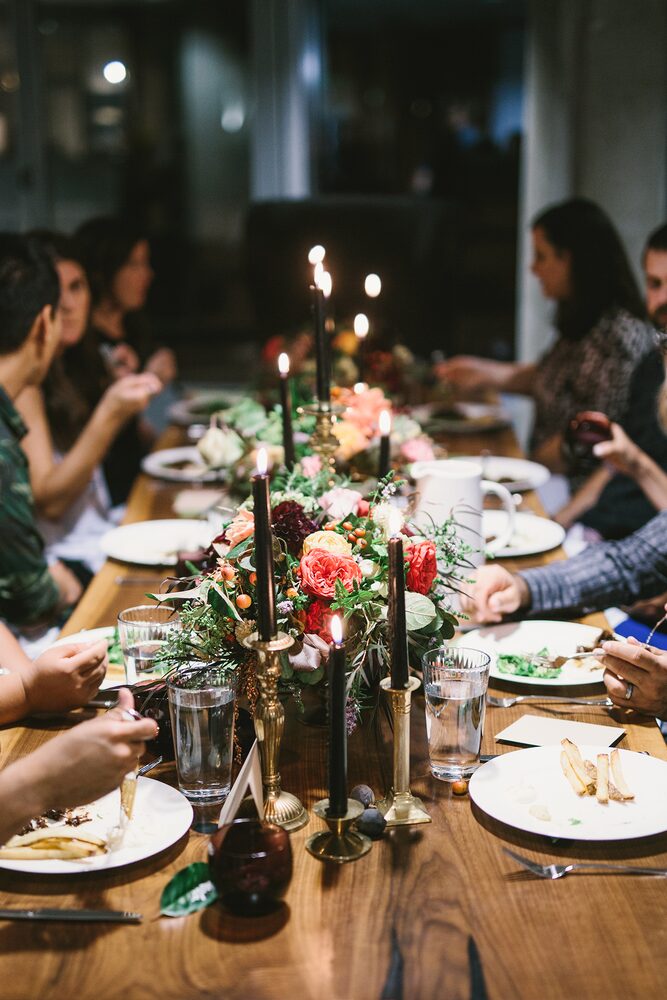 Candlelit dinner party with flowers along a long table