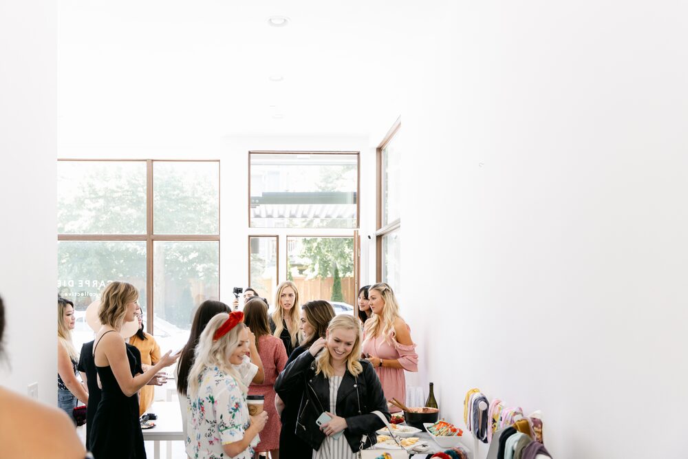 Guests mingling in a sunlit white studio
