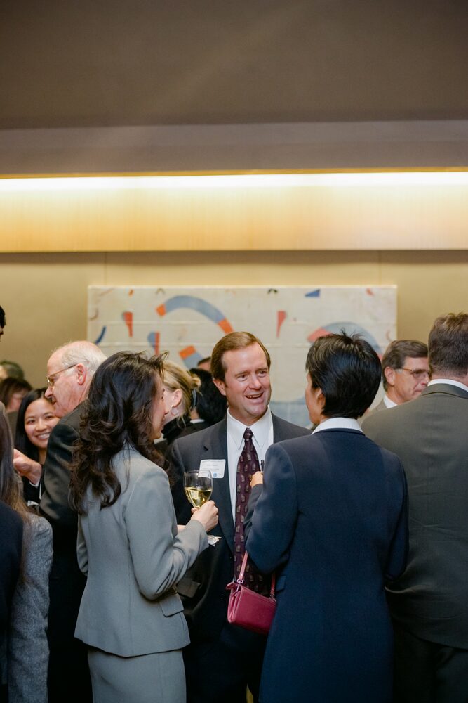 Guests mingling with drinks at an evening reception