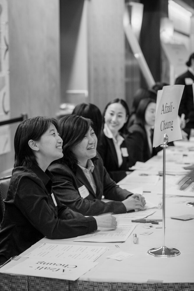 Black and white photo of guests checking in at a registration table
