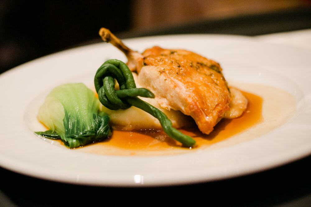 Plated entrée with vegetables on a white plate