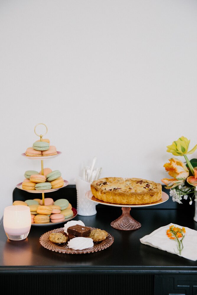 Dessert table with a tiered stand, macarons, and a tart