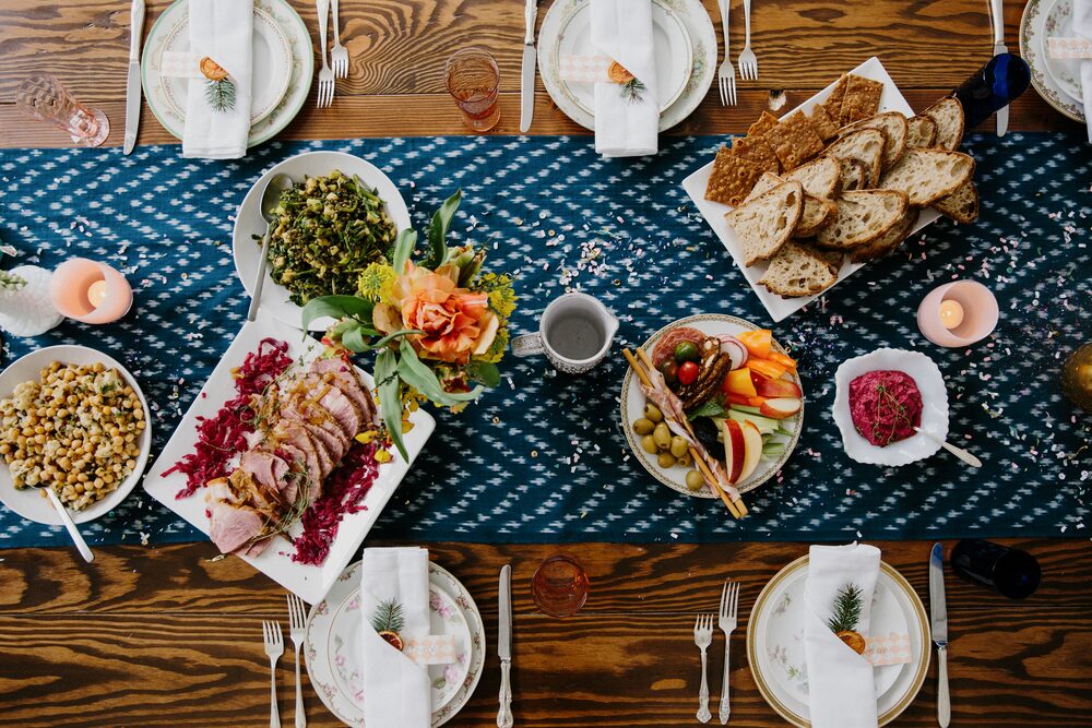 Overhead view of a shared table spread with platters and plates