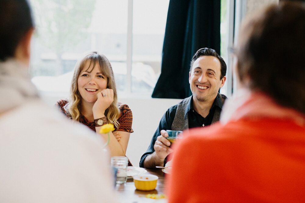 Guests laughing together at a dinner table