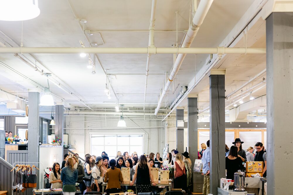 Wide view of a crowded market in a loft space