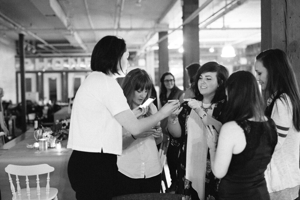 Black and white photo of guests browsing a vendor booth