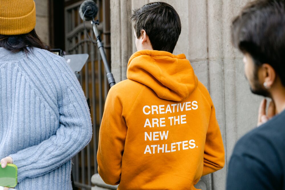 Crew members in colourful hoodies at a stone entrance