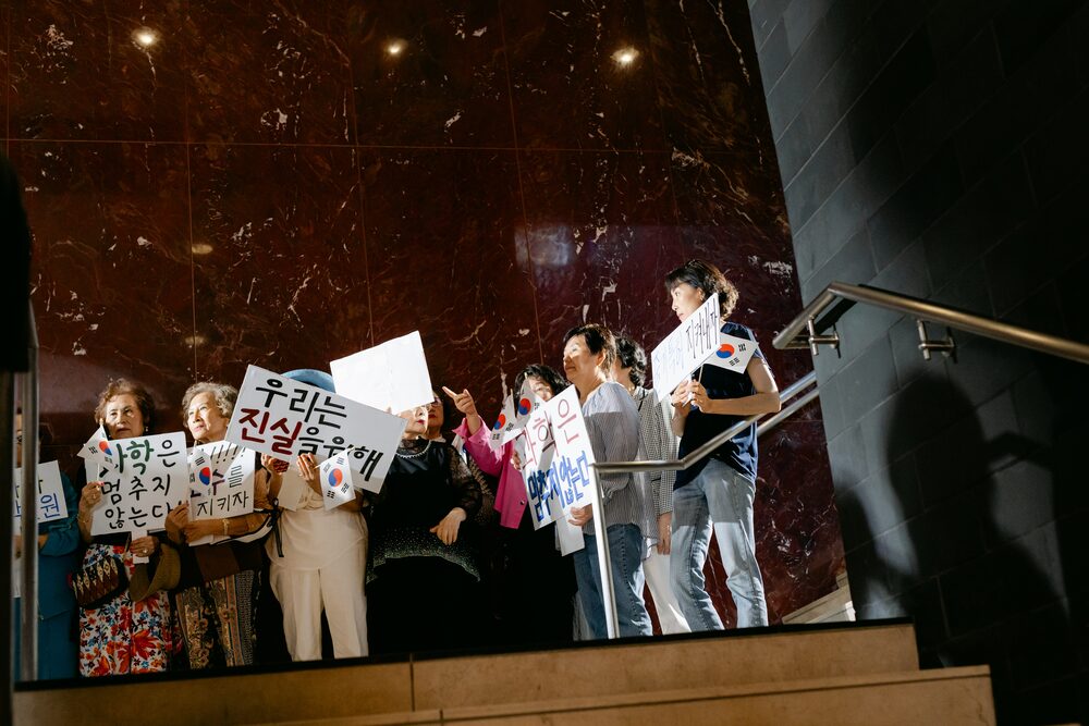 Crowd holding signs on a marble staircase