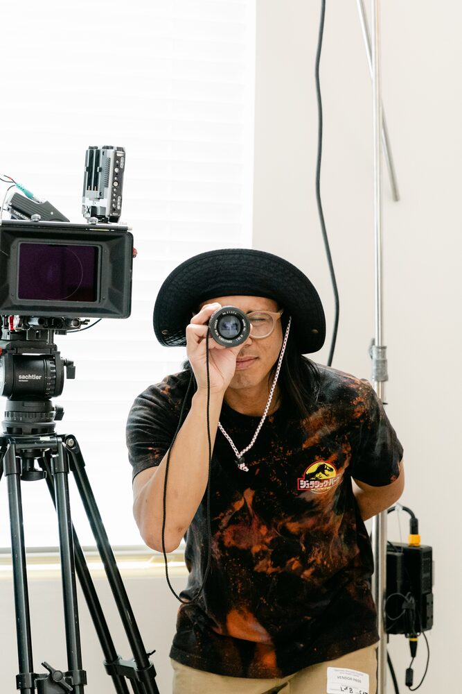 Camera operator in a hat behind a cinema camera