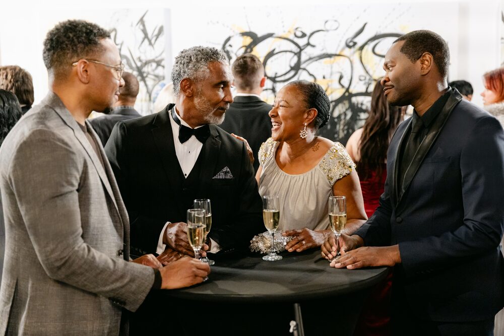 Guests toasting at a cocktail table in a gallery